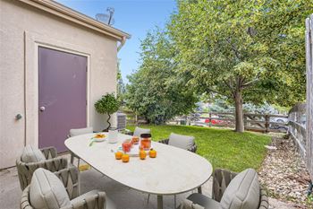 A table with chairs and oranges on it.
